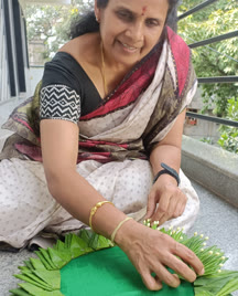 Participant arranging leaves on a thali