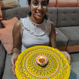 Participant holding a finished yellow thali